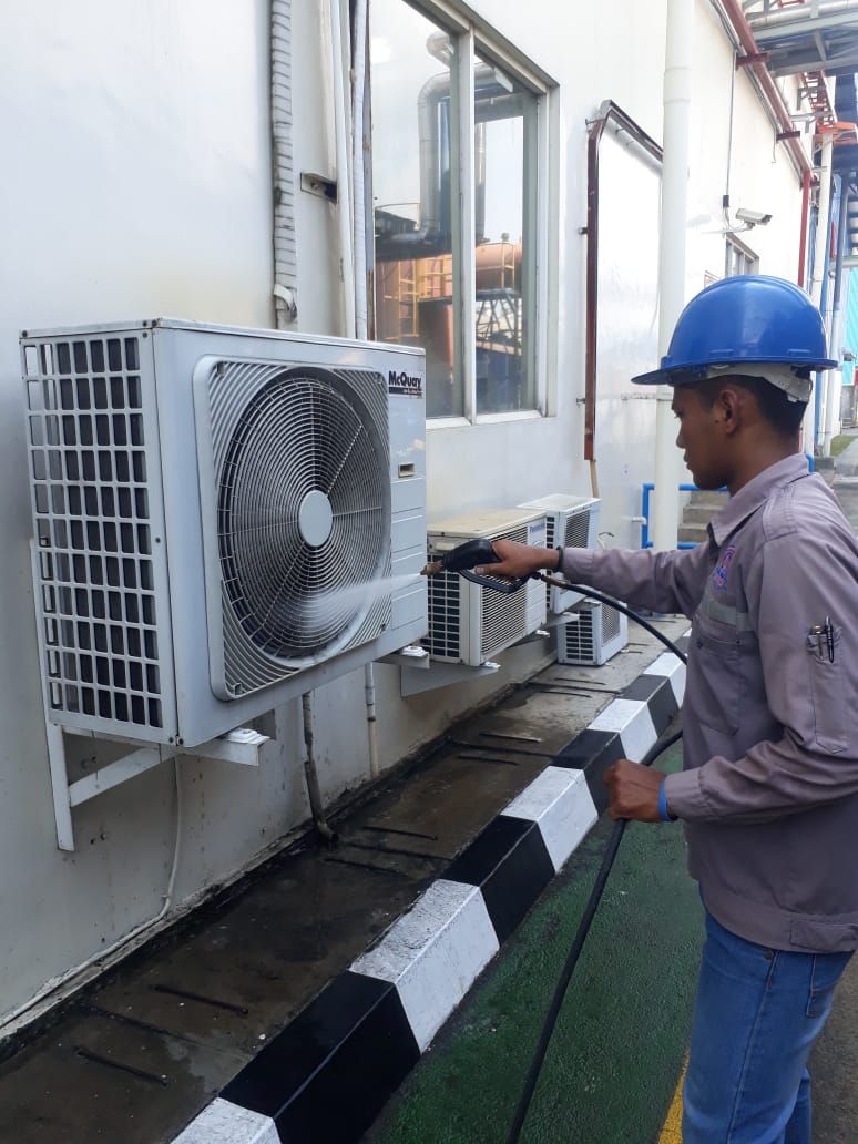 Teknisi menservis unit outdoor AC